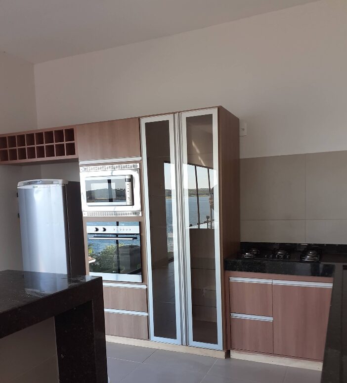 Armário planejado com portas de vidro e adega, integrado à cozinha