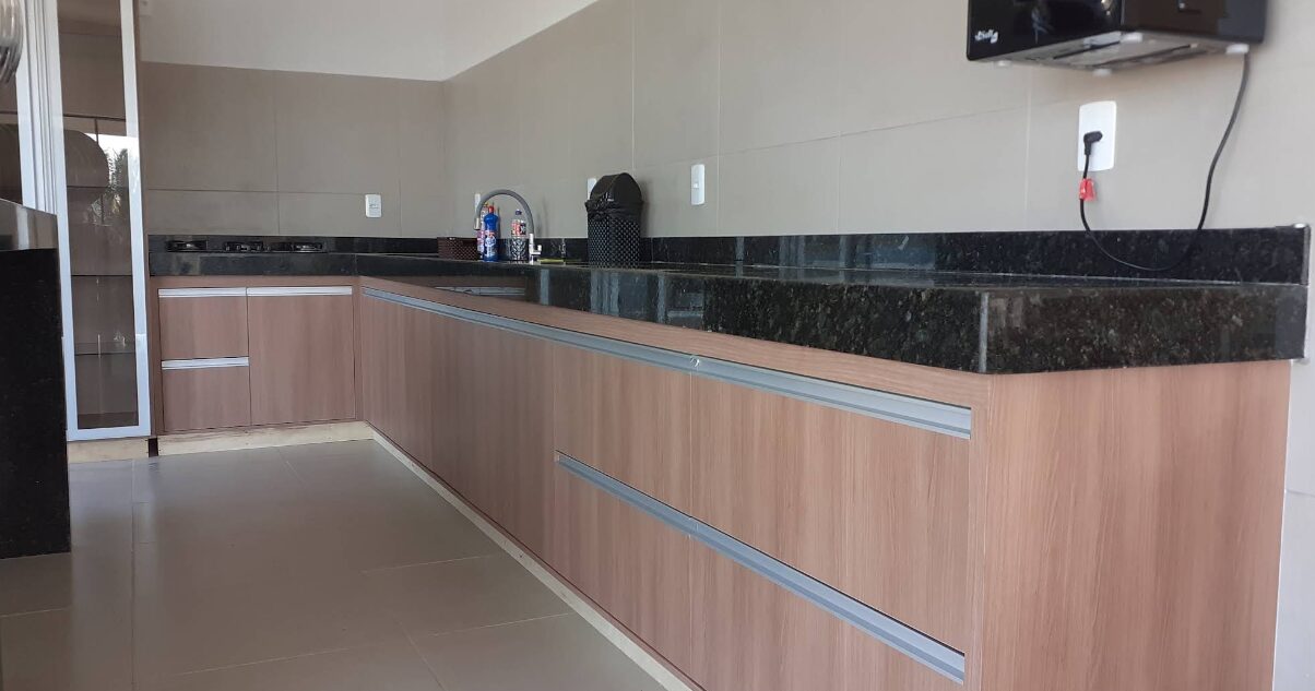 Bancada planejada em granito preto com armários em madeira